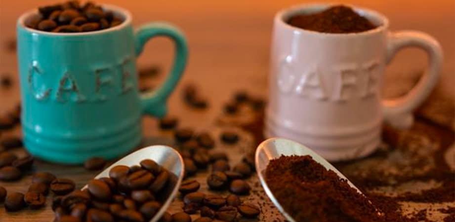 tazzine di caffè con chicchi e polvere di caffè