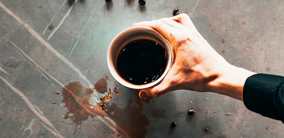 tazza di caffè con caffè versato a terra