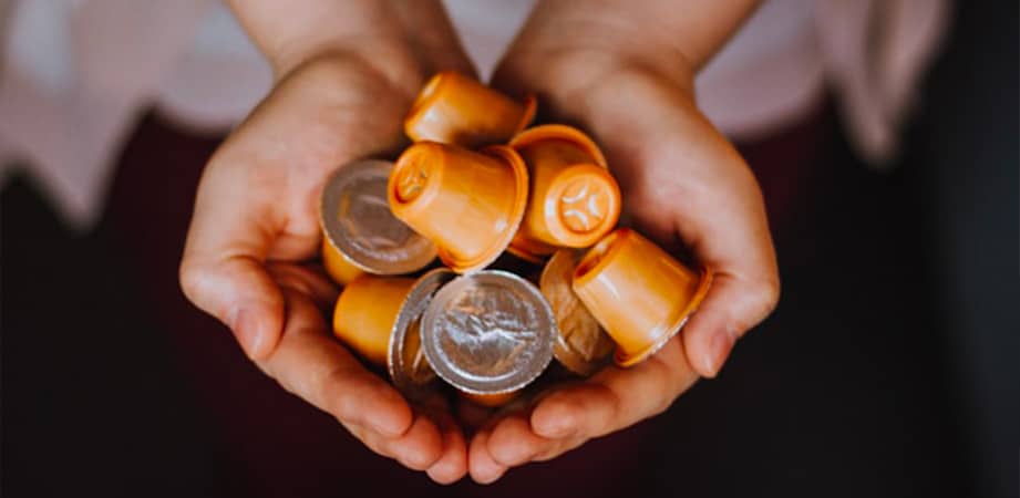 mani che mantengono capsule del caffè