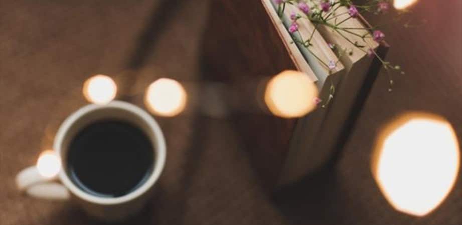 tazzina di caffè con libro e fiori