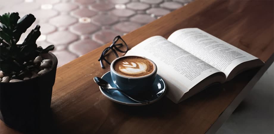 tazza di caffè con occhiali e libro