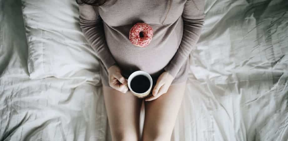 donna incinta con tazza caffè