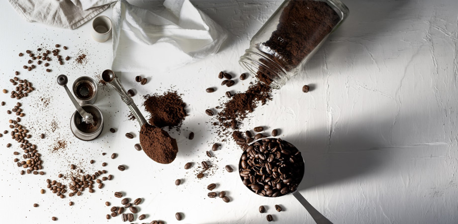 Caffè macinato, caffè in grani e tazza di caffè su sfondo bianco