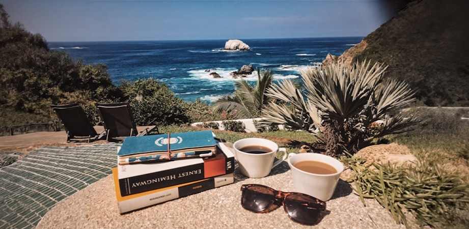libri e tazzina di caffè vista mare